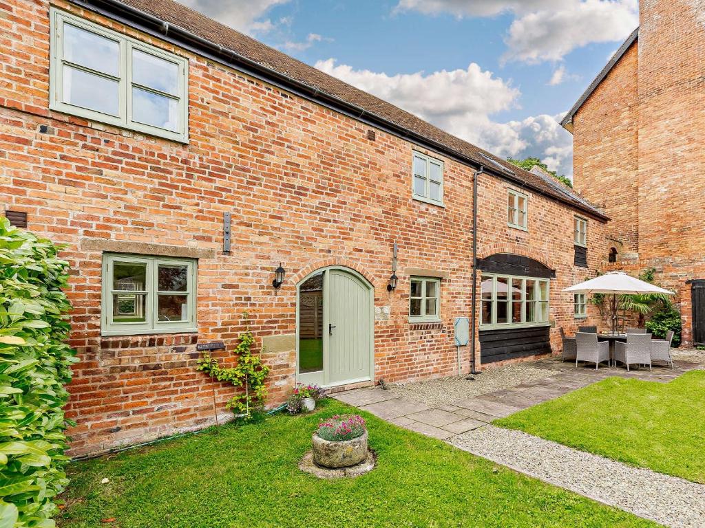 a brick house with a patio in the yard at 3 Bed in Church Stretton 76621 in Rushbury
