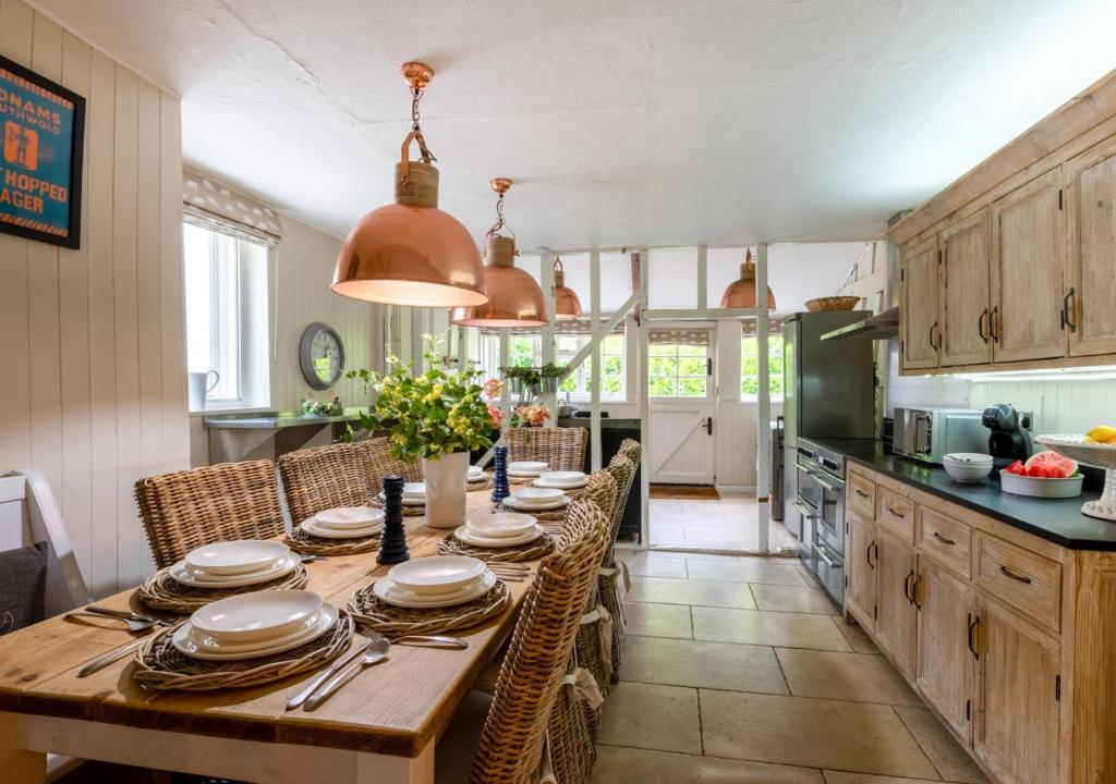 uma cozinha com uma mesa com pratos e utensílios em Church Farm em Halesworth