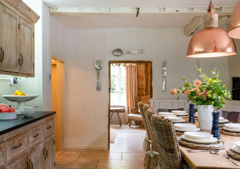 a kitchen with a long table with chairs at Church Farm in Halesworth