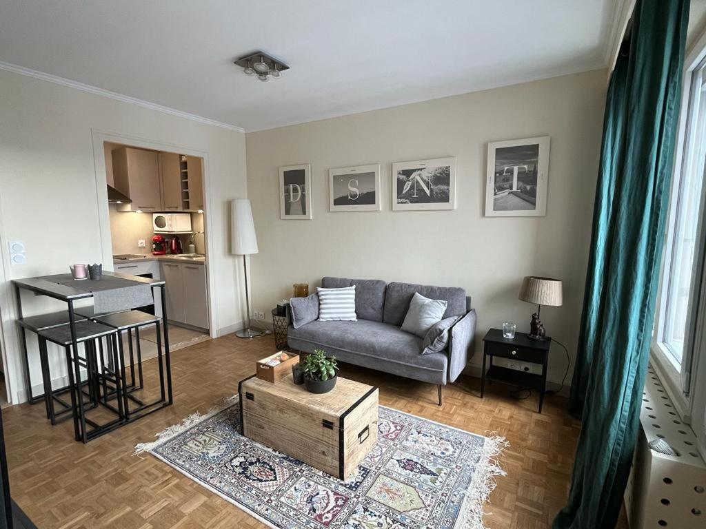 a living room with a couch and a table at Appartement Cosy Proche du Lac in Annecy