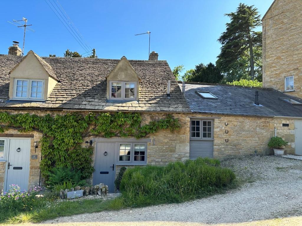 an old stone house with ivy on the side of it at 1 Bed in Longborough 52674 in Longborough