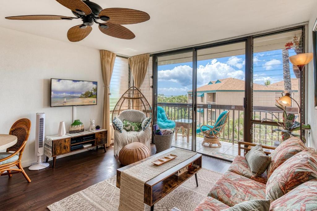 uma sala de estar com um sofá e uma grande janela em Maui Vista 2-301 - Modern and Bright Renovation em Kihei