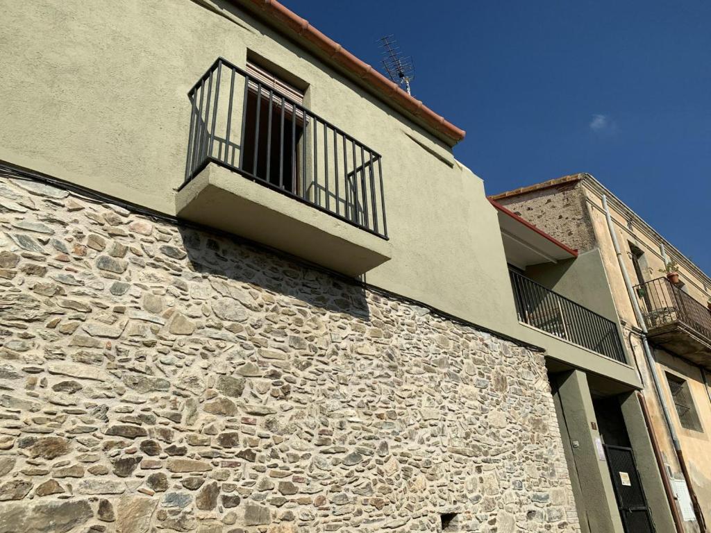 ein Steingebäude mit einem Fenster und einem Balkon in der Unterkunft Apartamento Vilamaniscle, 3 dormitorios, 6 personas - ES-228-169 in Vilamaniscle