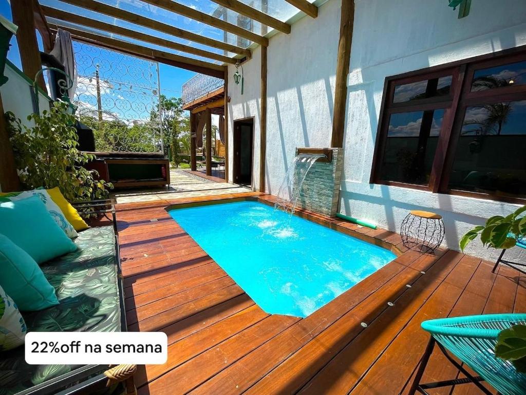 a swimming pool on a wooden deck next to a house at Rancho Fiori di Mari - Lago Corumbá IV in Alexânia