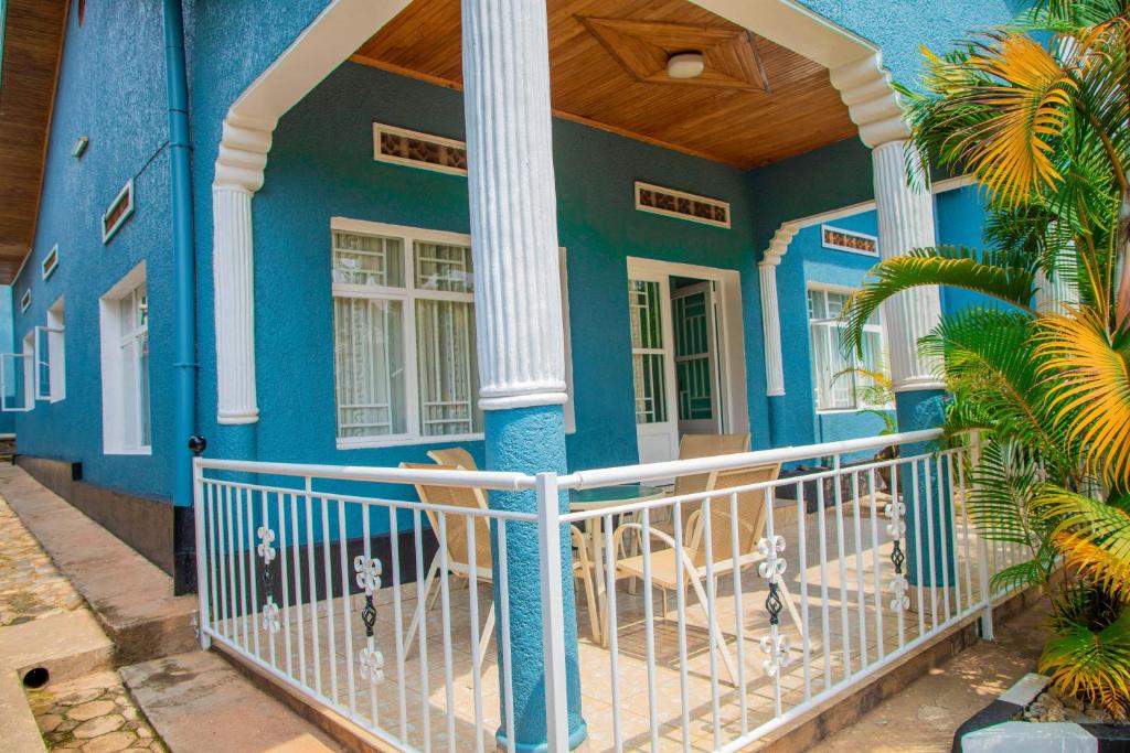 Casa azul con columnas blancas y porche en PEACE Homes, en Kigali