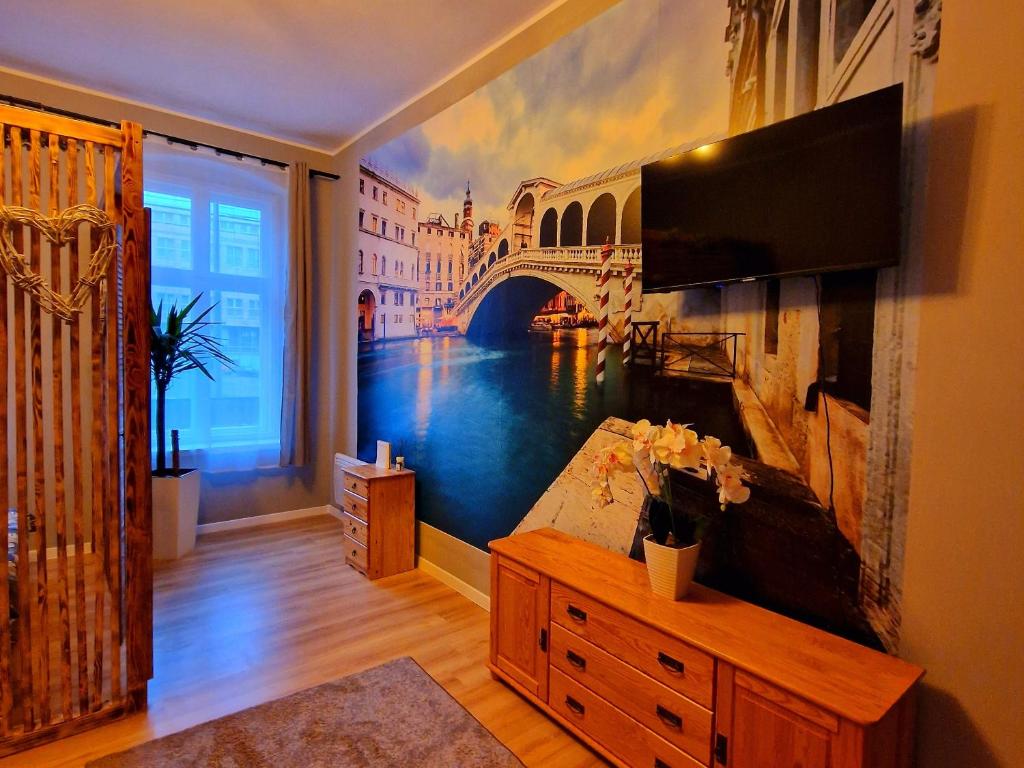 a living room with a painting of a bridge at Apartamenty Toskania No.4 Jacuzzi & Sauna in Poznań