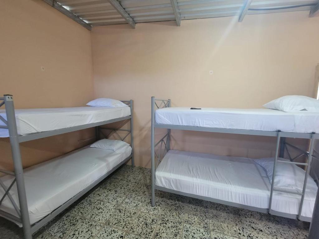 DanlíにあるHospedaje San Antonio,Danliの白い壁の客室で、二段ベッド2組が備わります。
