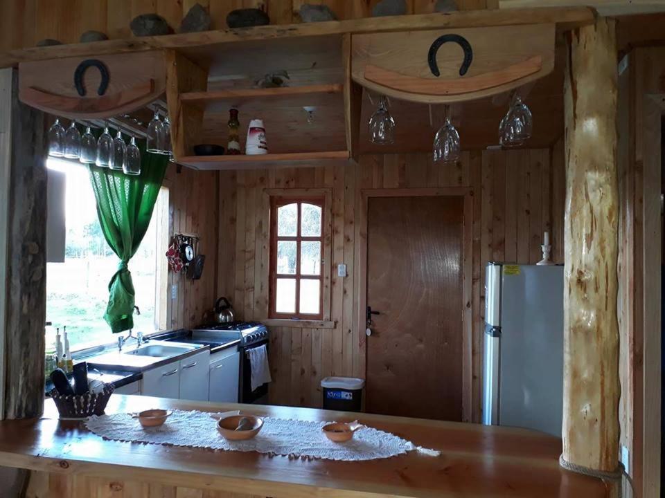 cocina con encimera y nevera en Cabañas Amanecer, en Riñinahue
