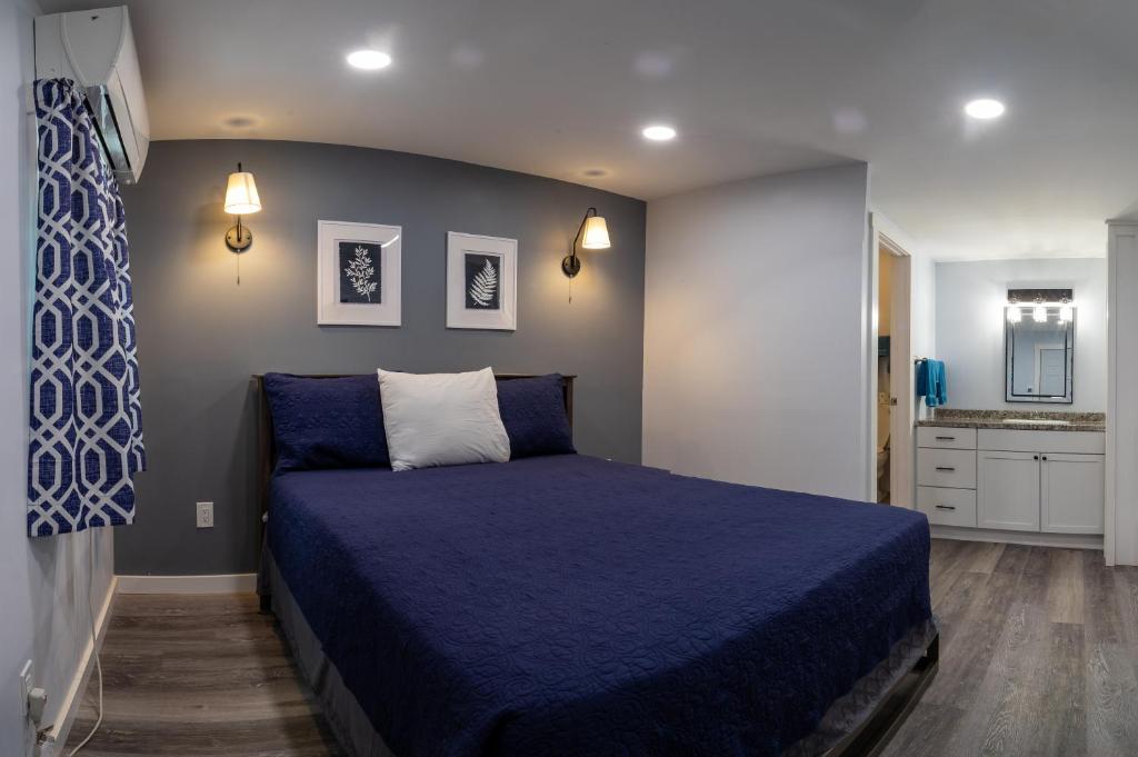 a bedroom with a bed with a blue bedspread at Robbins Motel in Bar Harbor