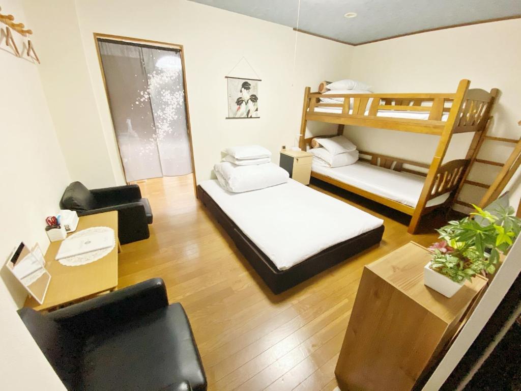 ein Zimmer mit zwei Etagenbetten und einem Schreibtisch in der Unterkunft Petit Hotel 017 / Vacation STAY 61793 in Tokushima
