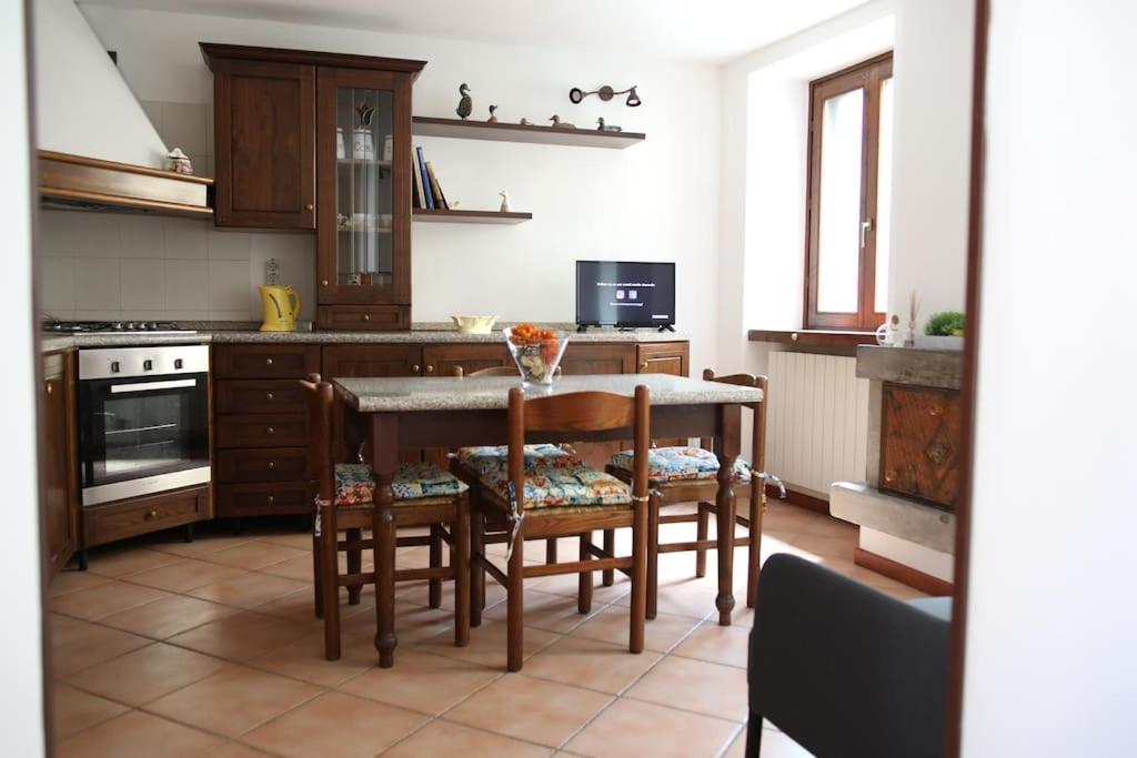 uma cozinha com uma mesa e algumas cadeiras e um fogão em Appartamento San Felice sul lago d'Endine em San Felice del Benaco