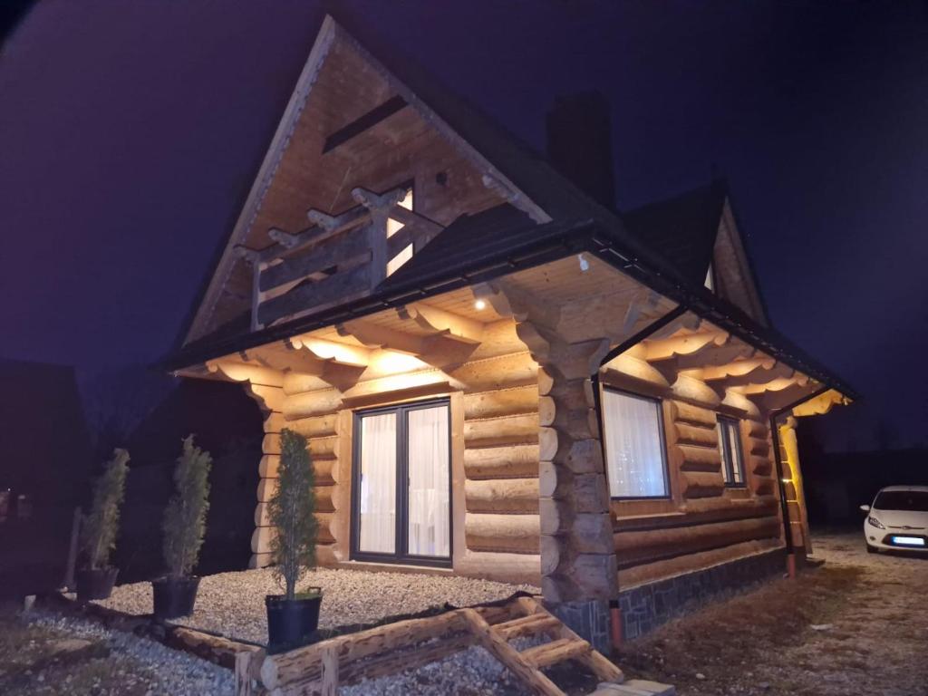 a log cabin lit up at night at Chochołowski Zakątek in Chochołów