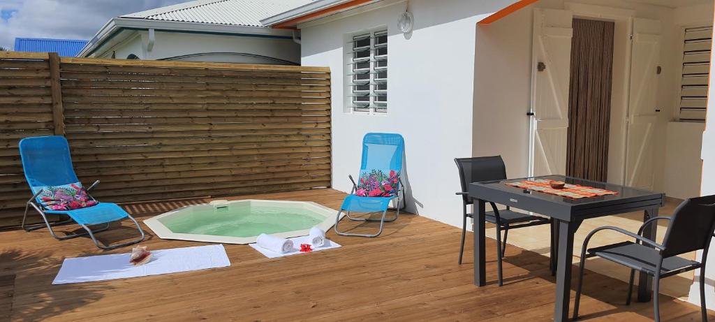 a patio with a table and chairs and a small pool at LES KOKI VILLA TROPICADELICE in Saint-François