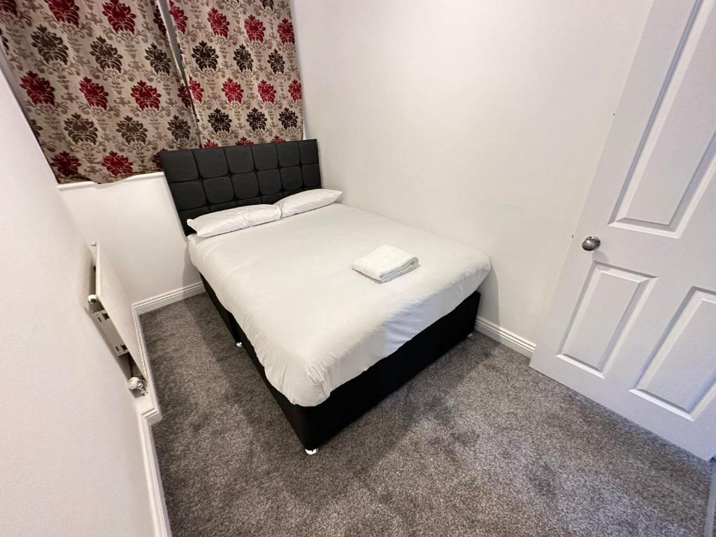 a small bed in a small room with a door at 3 bedroom garden house Maida Vale in London