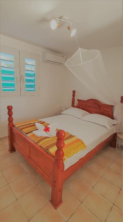 a bed with a wooden frame in a room at LES KOKI VILLA TROPICADELICE in Saint-François