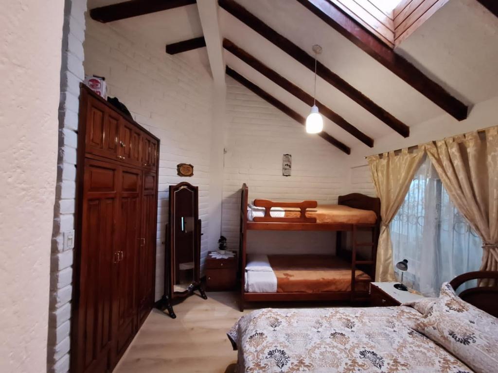 1 dormitorio con 2 literas y ventana en HERMOSA Y COMODA CASA FAMILIAR EN Baños, en Baños