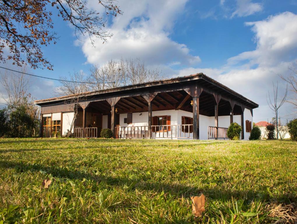a large building with a grass field in front of it at Traditional County House close to Trikala 
