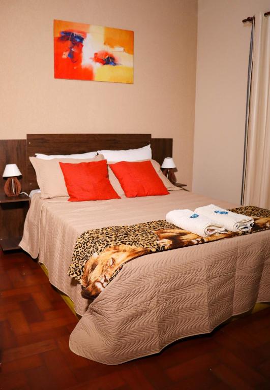 a bedroom with a bed with a dog laying on it at Pousada do Ribeirão in Andrelândia