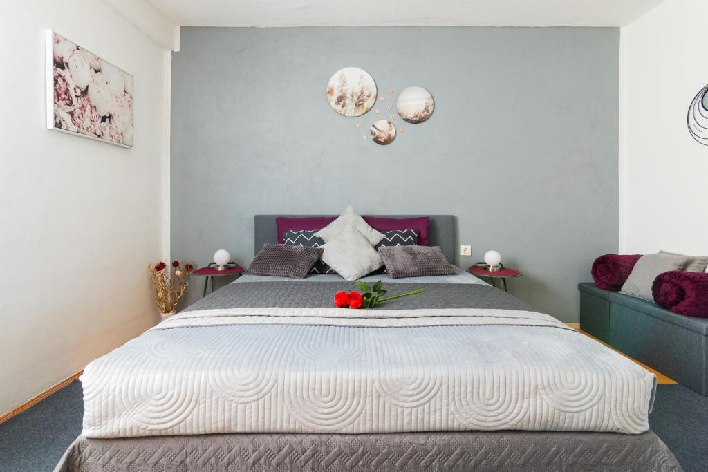 Un dormitorio con una cama grande con una flor. en Apartma Ella, en Lovrenc na Pohorju