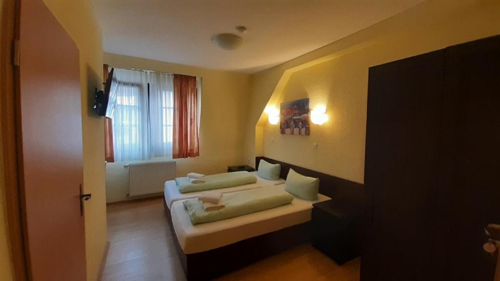 a hotel room with two beds and a window at Gästehaus Zu Herrenwiesen in Heidelberg