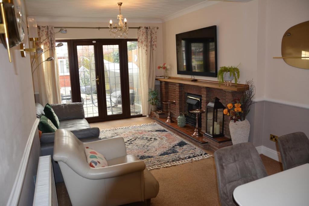 uma sala de estar com um sofá e uma lareira em Cozy, modern, spacious 4 bedroom house in london em Romford