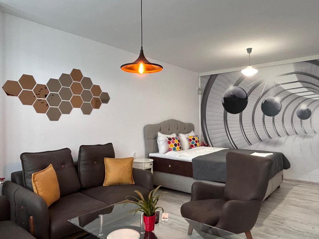 a bedroom with a bed and a couch and a table at Apartment Fire & Lux near the center in Razgrad