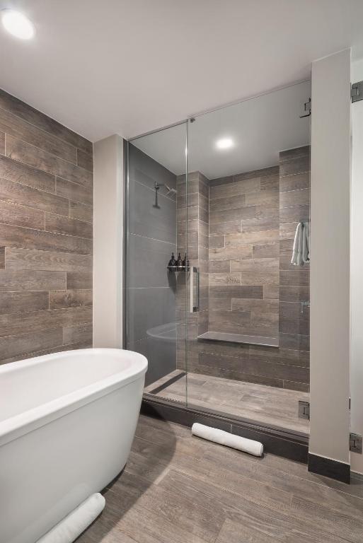 a bathroom with a tub and a glass shower at Hotel Van Zandt in Austin
