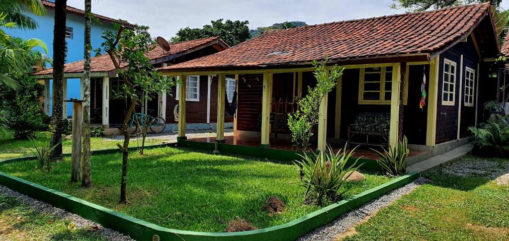 een klein huis met een groene tuin ervoor bij Chalé super aconchegante em condomínio com garagem in São Sebastião