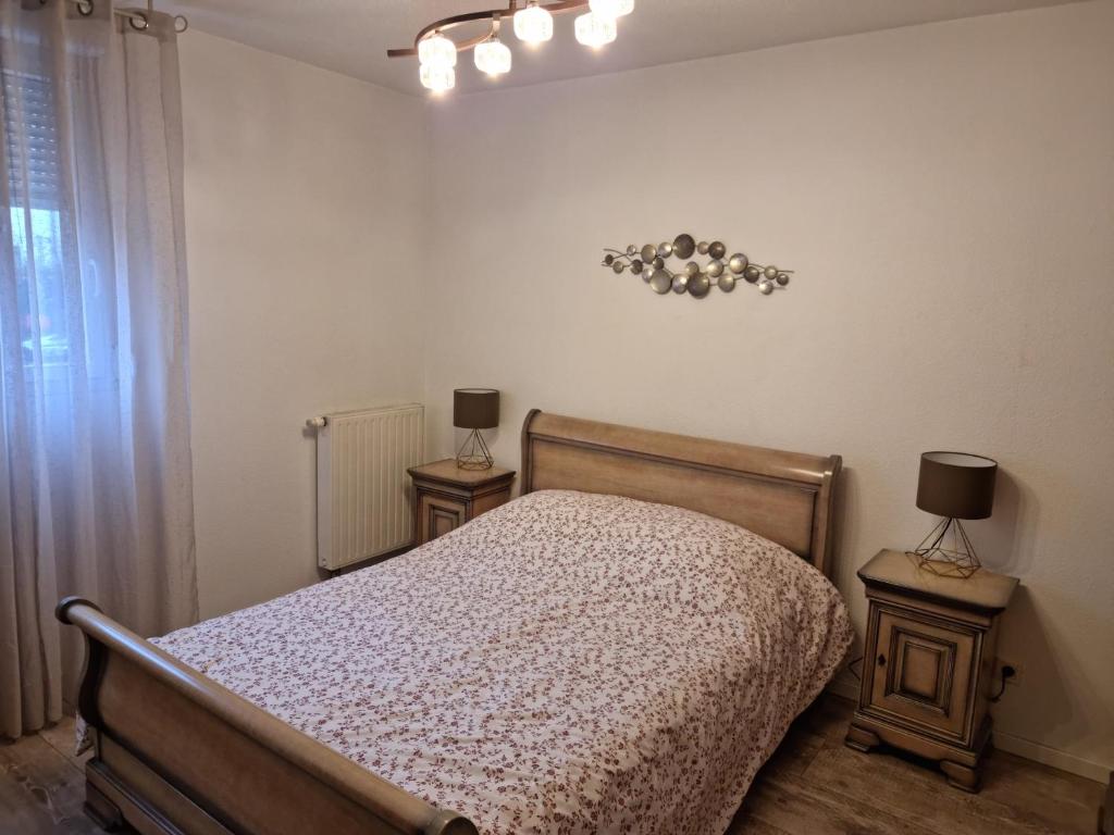 a bedroom with a bed with two night stands and two lamps at Résidence Villa d'Ambre in Colmar