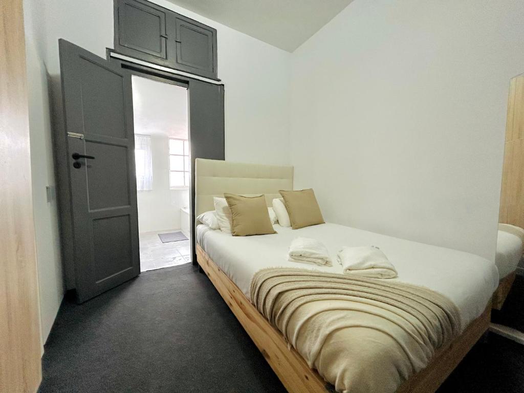 Schlafzimmer mit einem großen Bett und einer schwarzen Tür in der Unterkunft Low Cost Arroios Rooms in Lissabon