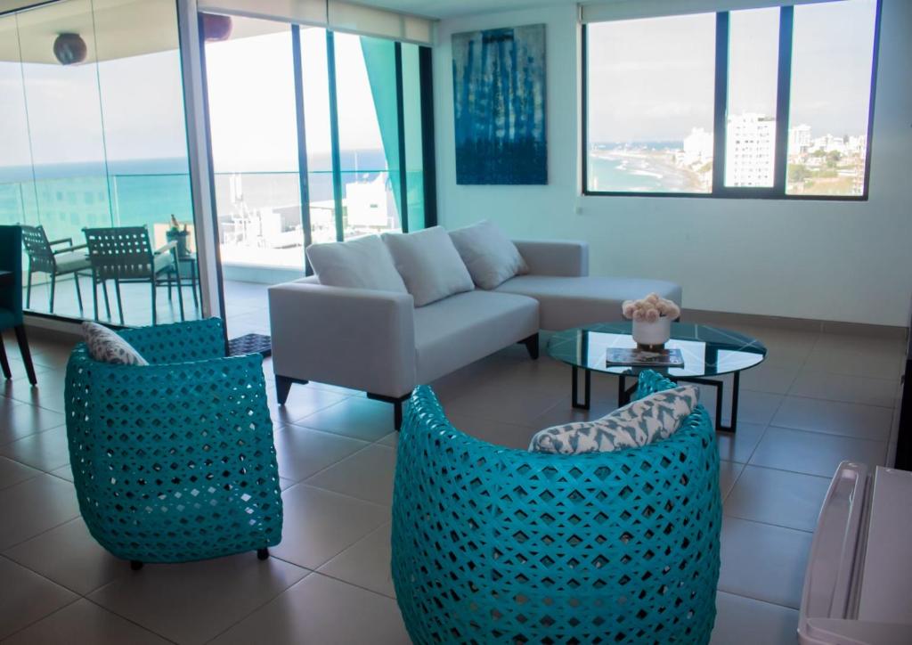 Una sala de estar con un sofá y sillas y una mesa. en Hermosa Vista Lateral al Mar Edif. Poseidon, en Manta