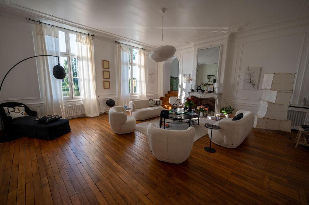 un ampio soggiorno con mobili bianchi e pavimenti in legno di MAISON HULOTTE a Amboise