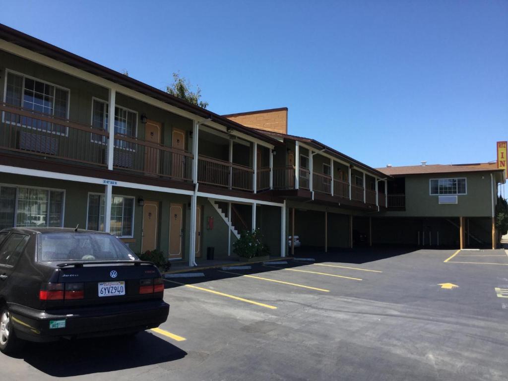 un coche aparcado en un aparcamiento frente a un edificio en Ritz Inn-San Francisco Airport SFO, en San Bruno