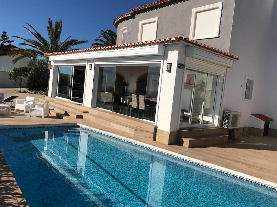 une maison avec une piscine en face d'une maison dans l'établissement Villa avec piscine vue mer cumbre del sol LA CASA V, à Cumbre del Sol