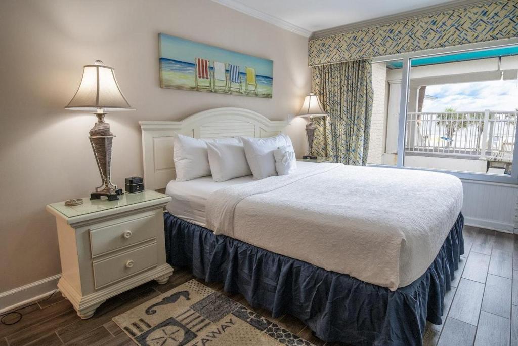 a bedroom with a large bed and a window at King Bed Ocean View 2nd Floor in Pawleys Island