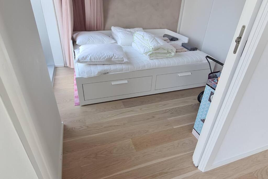 a small bedroom with a bed with white sheets and pillows at AArhus 115 in Aarhus