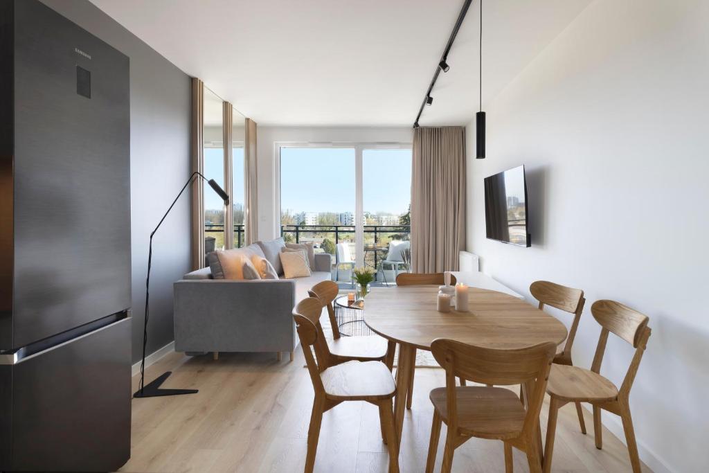 a kitchen and dining room with a table and chairs at Elite Apartments Majewskich in Gdańsk