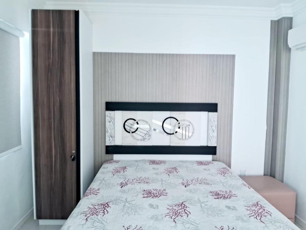 ein Schlafzimmer mit einem großen Bett mit einer weißen Tagesdecke in der Unterkunft Residencial Atalanta in Bombinhas