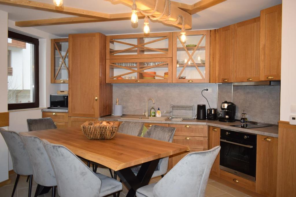 een keuken met een houten tafel en stoelen bij Супер луксозен апартамент в Winslow in Bansko