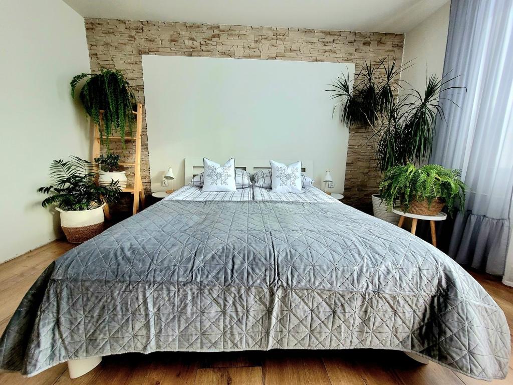 a bedroom with a large bed with plants in it at HAFCIK Apartamenty przyjazne dzieciom in Poronin