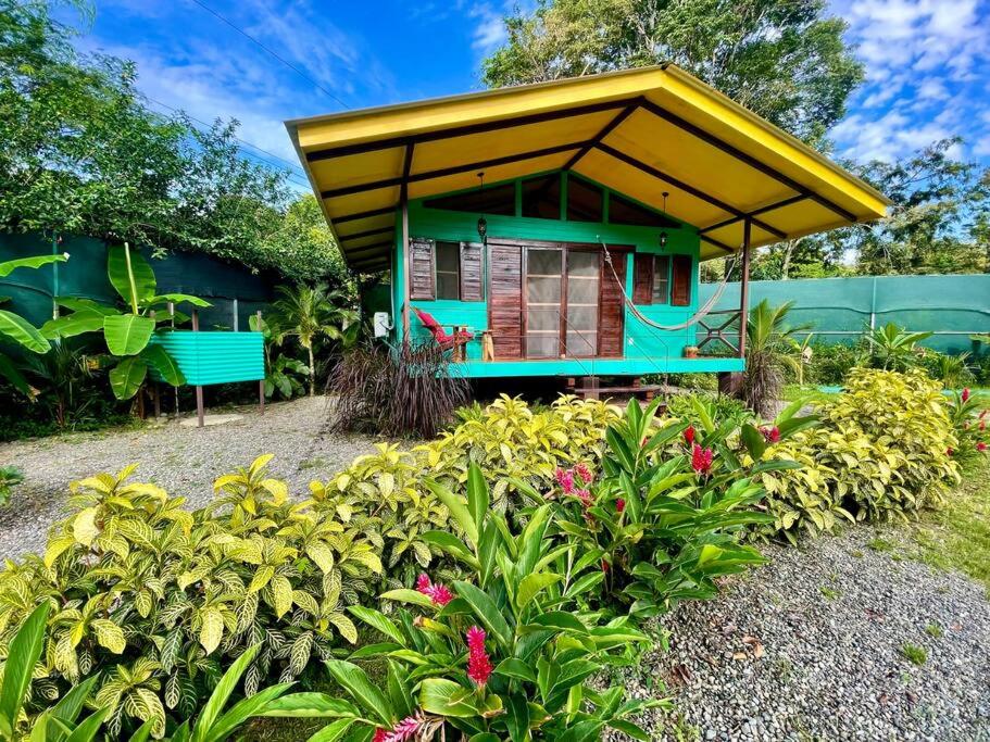 a small house with a yellow roof in a garden at Casita Kreyol Jungle Sanctuary/Walk to Playa Negra in Hone Creek