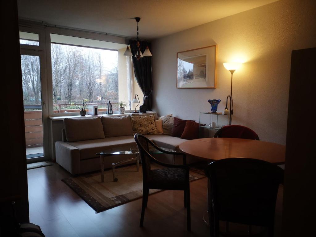 a living room with a couch and a table at Ferienwohnung Kärnten Ossiacher See zwei Zimmer Appartement direkter Seezugang Strand beheizte Schwimmhalle in Bodensdorf