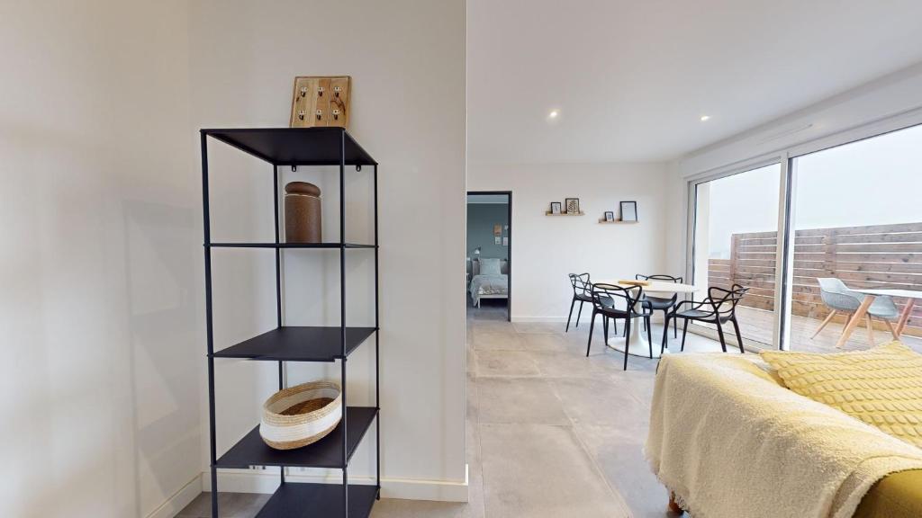 een slaapkamer met een boekenplank naast een bed bij Appartement Premium avec Terrasse - Parking privatif Gratuit - Fibre Wi-Fi - À 2 min Centre-Ville Dole in Dole