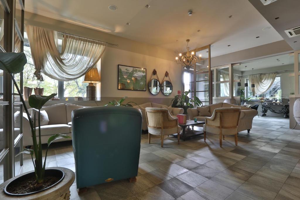 a living room with a couch and chairs and a plant at Hotel Le Corderie in Trieste