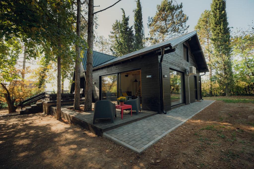 ein kleines Haus mit einer Terrasse und Bäumen in der Unterkunft Kuća za odmor Vrdnik in Vrdnik