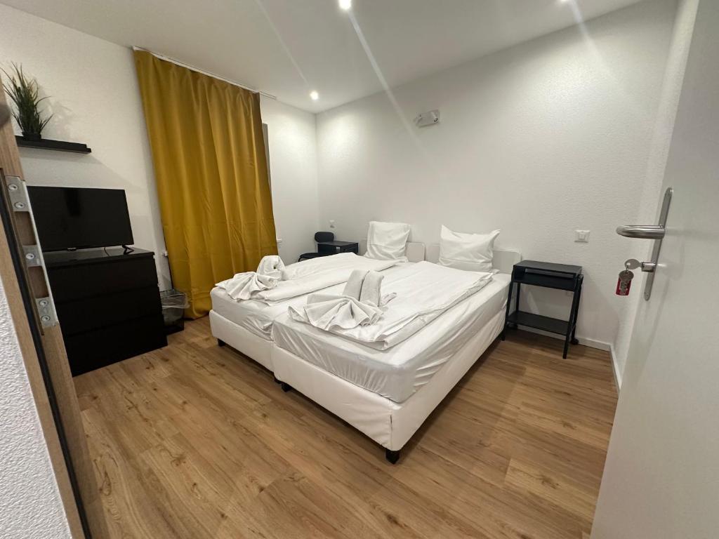 a bedroom with a white bed and a television at Hotel Restaurant Krebs in Grenchen