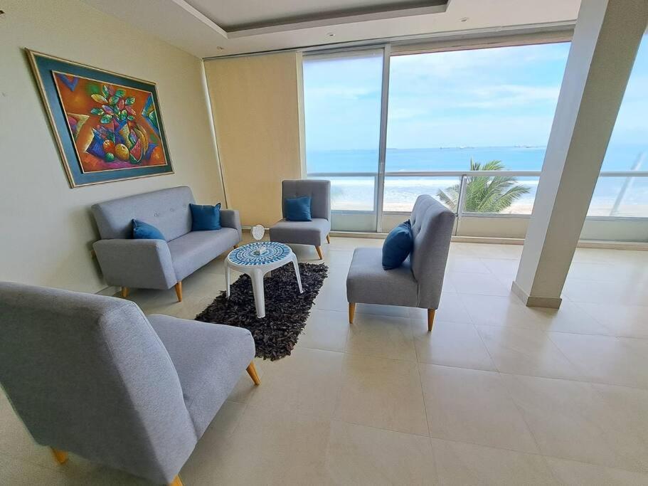 a living room with couches and chairs and a large window at Departamento con hermosa vista frente al mar cerca de Puntablanca in La Libertad