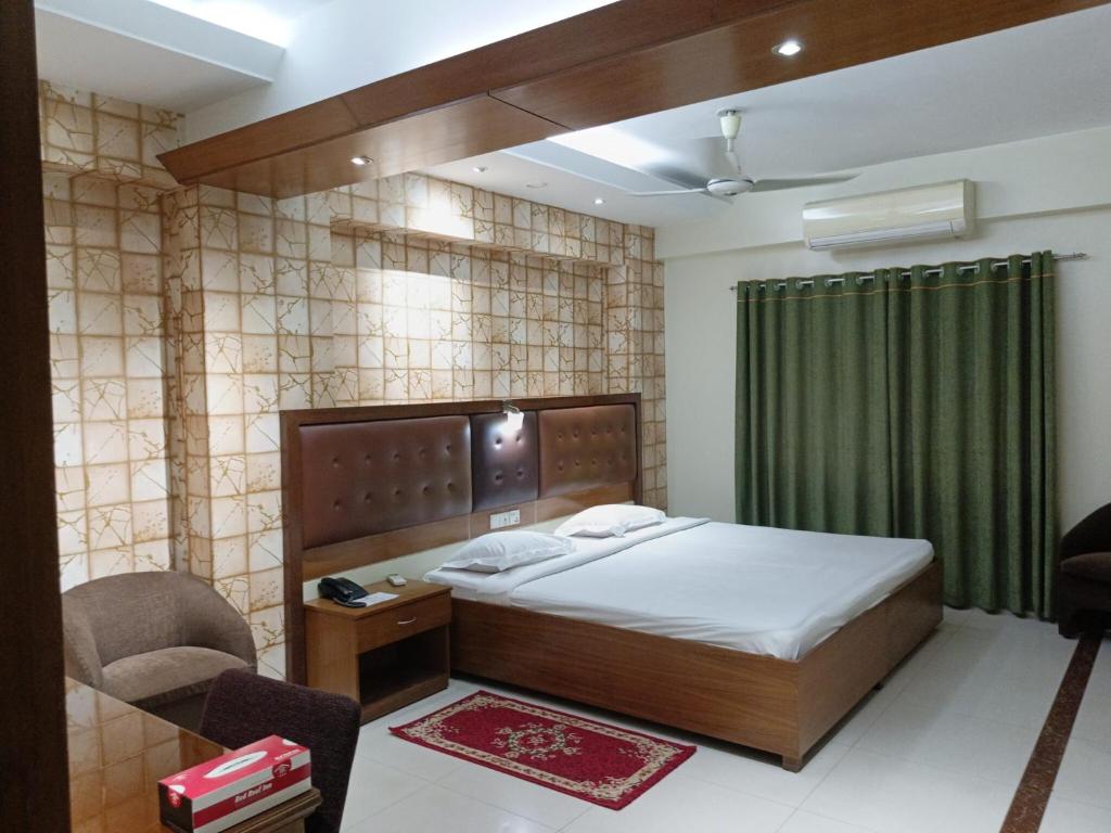 1 dormitorio con 1 cama y cortina verde en Hotel Red Roof Inn en Comilla