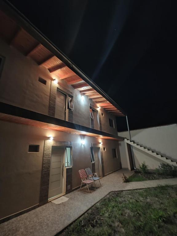ein Haus mit einem Balkon in der Nacht mit einem Stuhl in der Unterkunft Departamentos Rimasha in Federación
