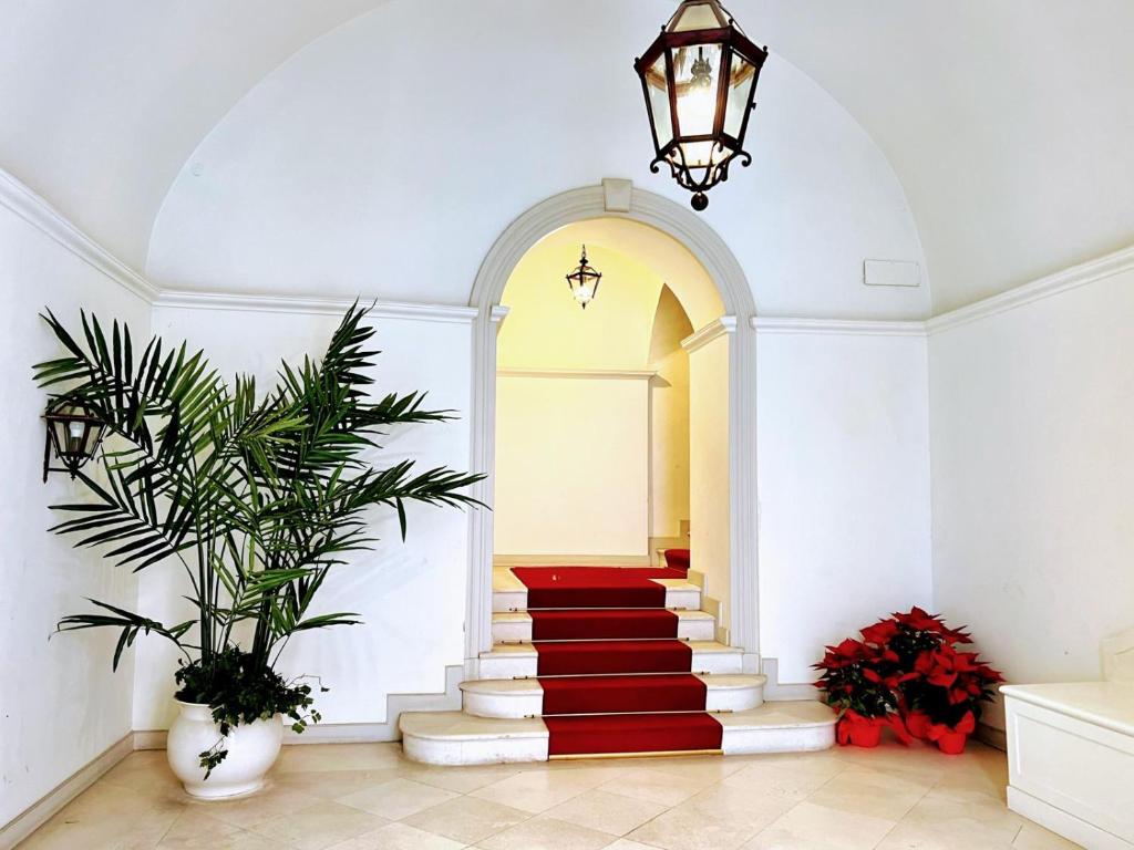 a hallway with a red carpeted staircase in a building at Andrea's 12 in Bari